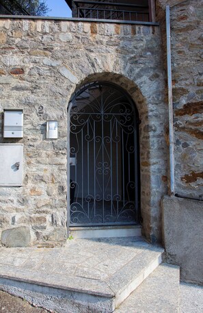 A stone building with a metal gate, a mailbox, and a utility box. - Apartment on the Sentiero Valtellina bike path, just a few minutes from Lake Como (Morbegno)