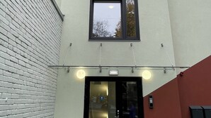 Een gebouw met een bakstenen gevel, een groot raam en een deur met een ruit.