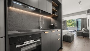 A modern kitchen with a built-in oven, microwave, and a sleek faucet.