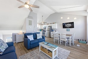 Un apartamento moderno con sala de estar, cocina, comedor y ventilador de techo.