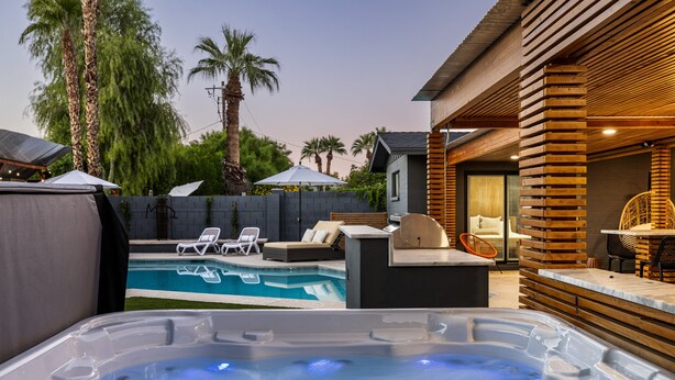En baghave med swimmingpool, jacuzzi og udendørs siddeområde.