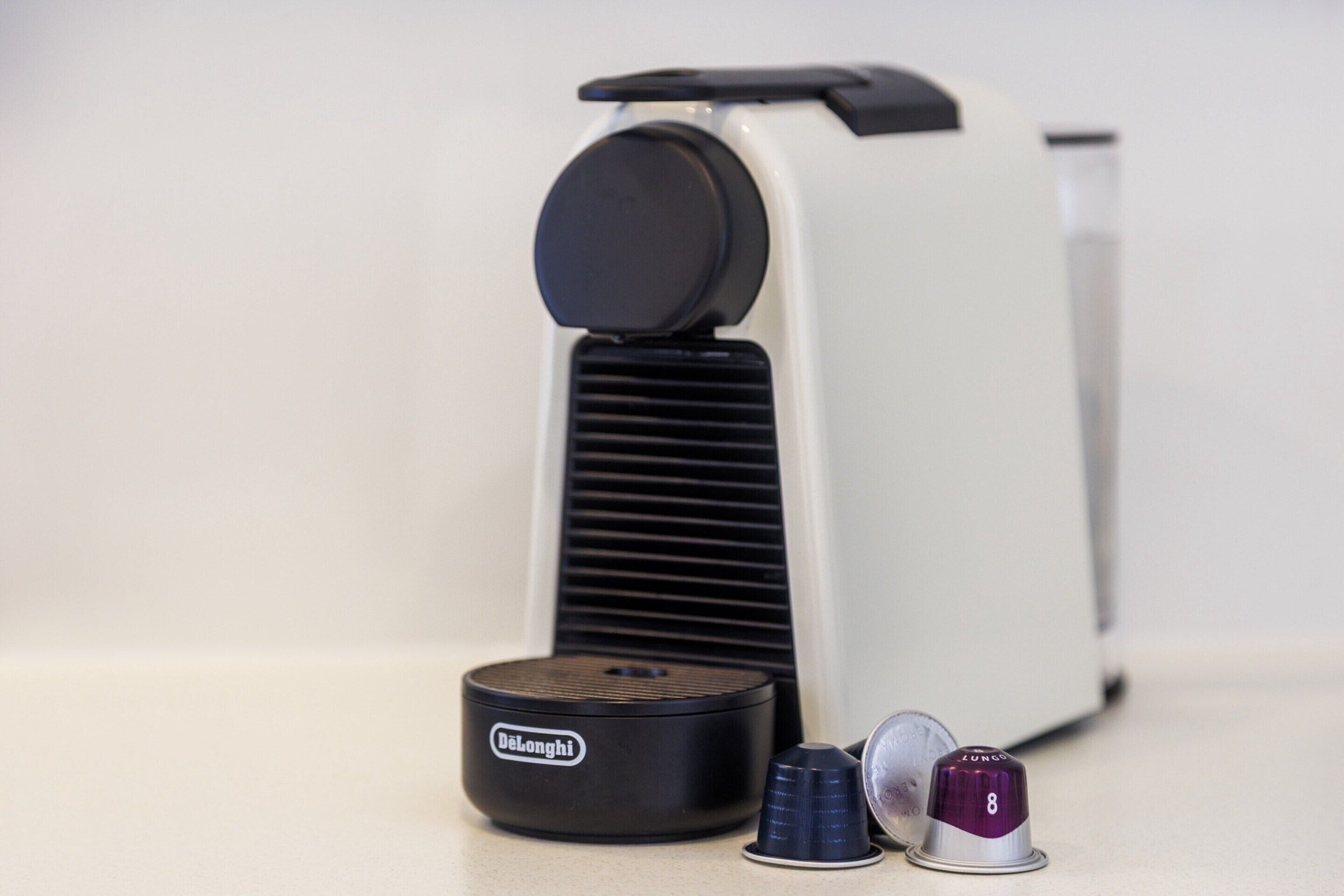 A vintage Belonghi espresso machine with a black and white design, accompanied by two blue cups and a purple container with the number 8.