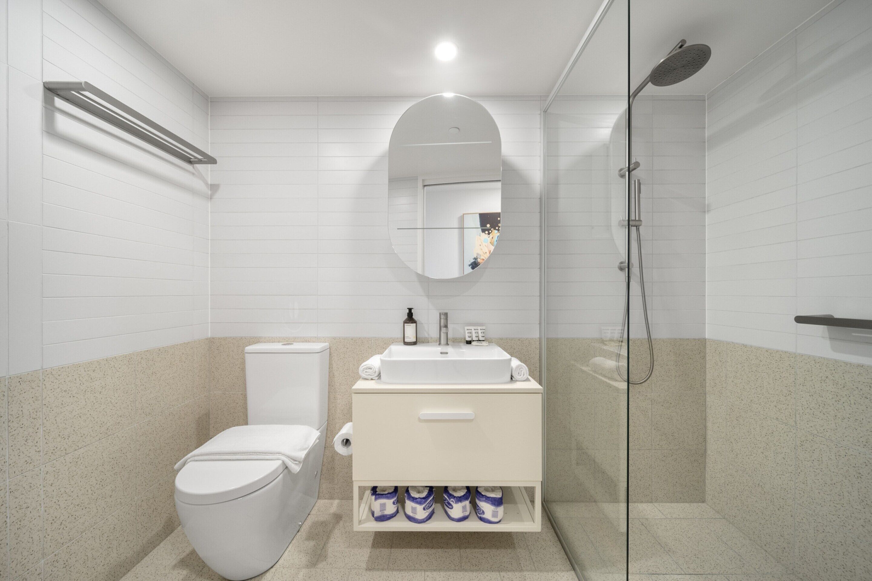 Un baño moderno con inodoro, lavamanos y ducha.