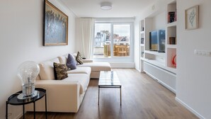 Een moderne woonkamer met een bank, salontafel en een groot raam met uitzicht op de stad.