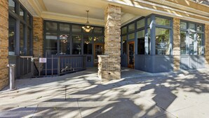 A building entrance with large windows, a stone pillar, and a hanging light fixture. - Panther City Pad - Downtown Fort Worth (Fort Worth)