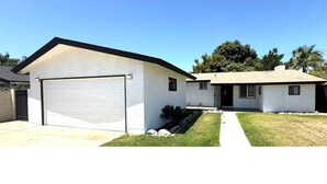 A two-story house with a garage and a small attached structure. - 3-bedroom house near Disneyland in Anaheim with AC (Anaheim)