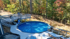 Um quintal com piscina, espreguiçadeiras e banheira de hidromassagem.