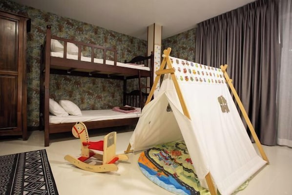 A bunk bed with a tent set up in a room with floral wallpaper.