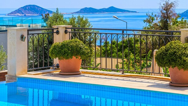 A rooftop pool with a view of the sea and islands.