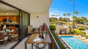 Ein Balkon mit Essbereich, einer Küche und einem Swimmingpool.