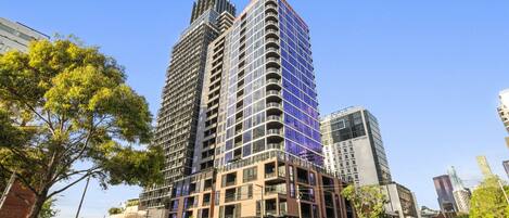 A modern high-rise building with multiple floors, large windows, and a prominent corner design.