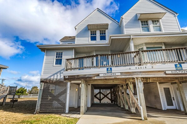 A two-story house with a balcony and a covered entrance.
