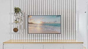 A flat-screen TV mounted on a wall with a beach scene. - Studio4: Bondi Chic Interiors With Rooftop Pool (Sydney)