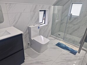 Een douche, handdoeken, toiletpapier