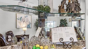 Una encimera de cocina con un atril para menú, un shaker de cócteles y una planta decorativa.