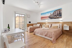 A hotel room with two beds, a dining table, and a painting on the wall. - Apartment 'Platinum - Il Centro Luxury Suites' with Balcony, Wi-Fi & Air Conditioning (Bari)