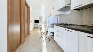 A modern kitchen with white cabinets, a black countertop, and a tiled backsplash. - Studio Apartment 'Francesca, Mono Deluxe B' with Shared Terrace, Wi-Fi and Air Conditioning (Peschici)