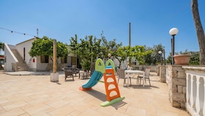 A playground with a slide and climbing structure, outdoor seating, and a building with a staircase. - Studio Apartment 'Francesca, Mono Deluxe B' with Shared Terrace, Wi-Fi and Air Conditioning (Peschici)