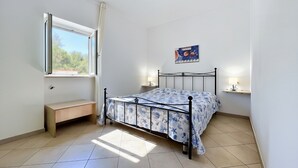 A bedroom with a bed, a bench, a window, and a wall-mounted shelf. - Studio Apartment 'Francesca, Mono Deluxe B' with Shared Terrace, Wi-Fi and Air Conditioning (Peschici)