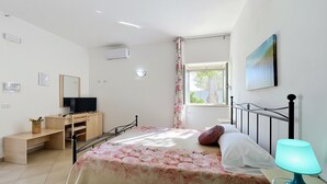 A bedroom with a bed, a desk, a television, a lamp, and a window. - Studio Apartment 'Francesca, Mono Standard A' with Shared Terrace, Wi-Fi and Air Conditioning (Peschici)