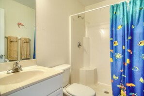 Une salle de bain avec un lavabo, des toilettes et une douche.