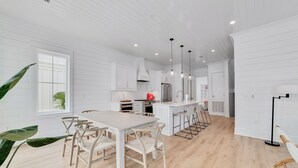 A spacious kitchen with white cabinetry, a central island, and pendant lighting. - Luxury 5BR, Pool, Walk To Beach, Private Boat Slip & Fishing Pier, Sleeps 15 (Orange Beach)