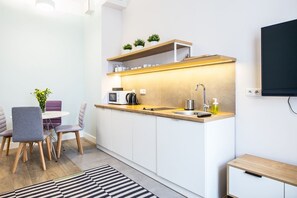 Une cuisine compacte équipée d’une cuisinière intégrée, d’un évier et d’un petit coin repas avec une table et des chaises.