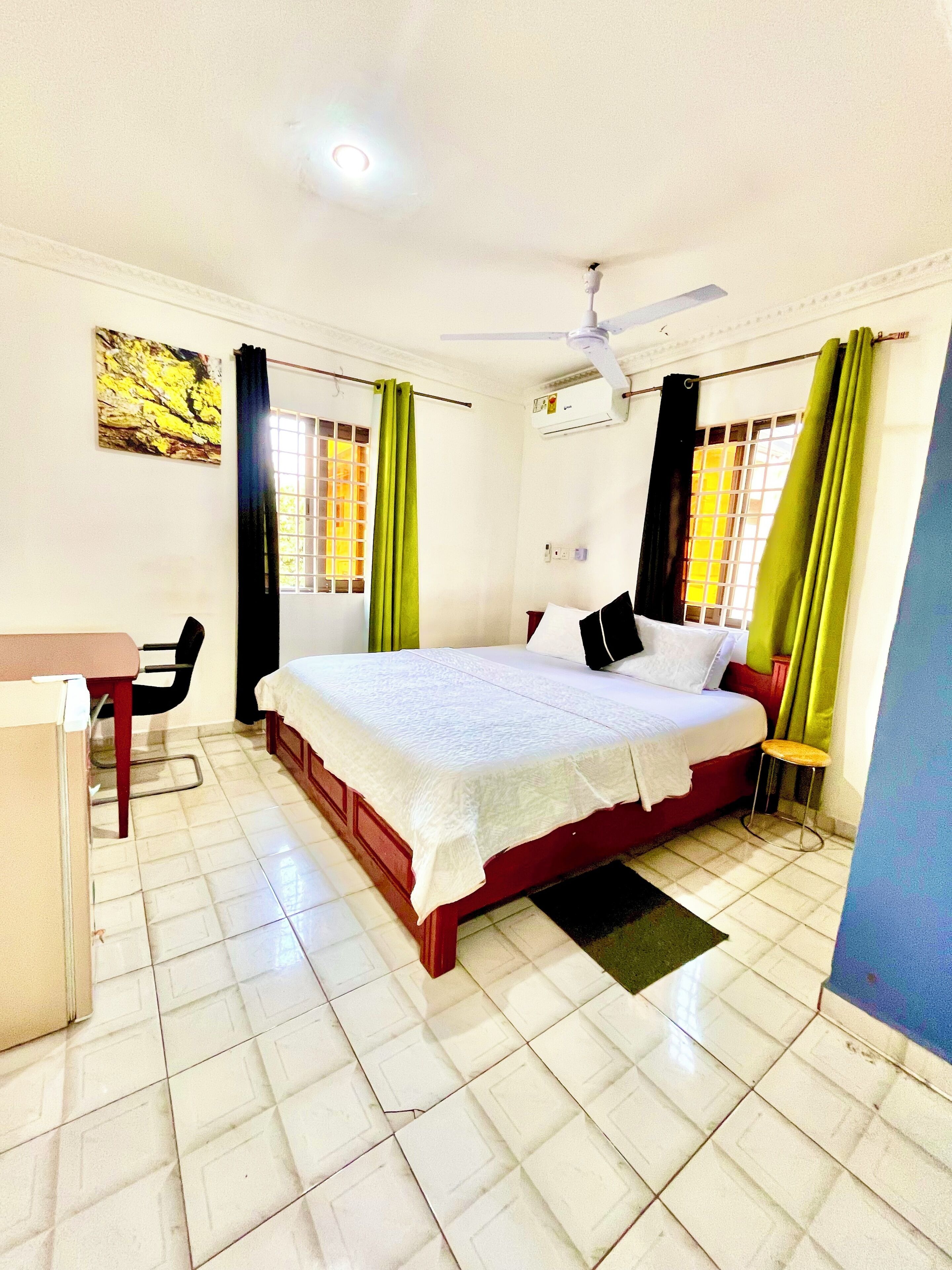 A bedroom with a bed, a desk, and a chair.