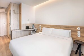 A modern hotel room with a large bed, a desk, a chair, and a small table. - B&B Hotel Vila Do Conde (Vila do Conde)