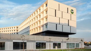 A modern hotel building with a flat facade, large windows, and a logo on the top right. - B&B Hotel Vila Do Conde (Vila do Conde)