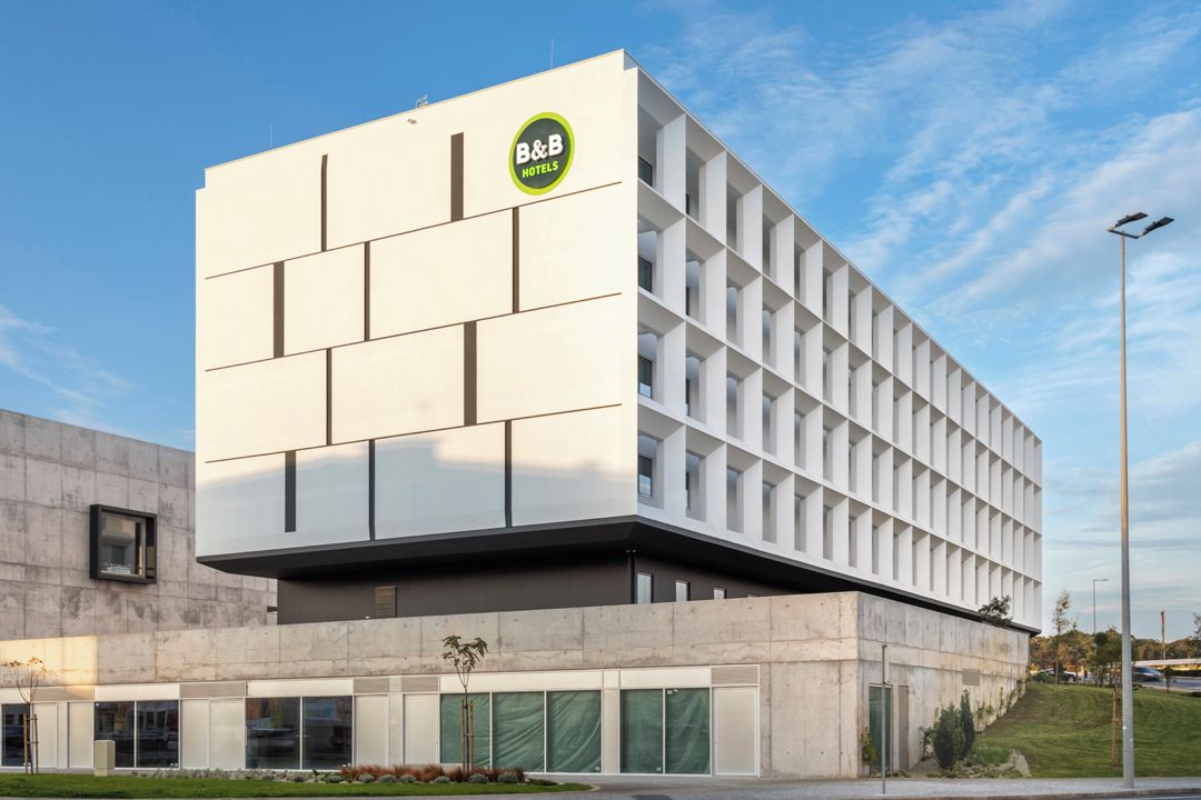 Um hotel moderno tipo bed and breakfast com fachada limpa e geométrica e um logotipo bem visível.