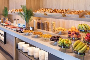 A buffet with various food items, including fruits, pastries, and cereals. - B&B Hotel Vila Do Conde (Vila do Conde)