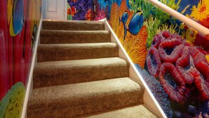 Una escalera con un mural vibrante de vida marina en las paredes.