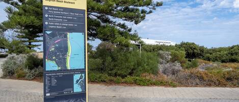 A directional sign at Leighton Beach Boulevard with a map and travel times to nearby locations.