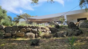 A modern building with a stone wall and a hammock.