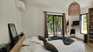 A bedroom with a bed, a desk, a chair, a TV, and a wardrobe.
