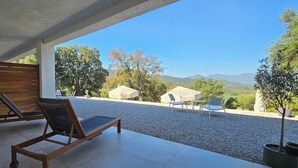 A covered outdoor seating area with a view of the countryside.