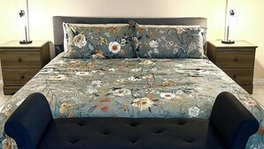 A bed with a floral bedspread, two nightstands, and a bench. - Marvelous 4-bedroom house in Houston with large backyard in quite neighborhood (Houston)