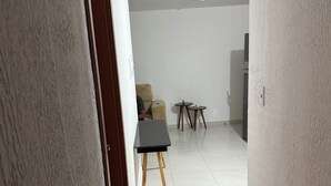 Uma sala ampla com um sofá, uma mesinha e duas mesas laterais.