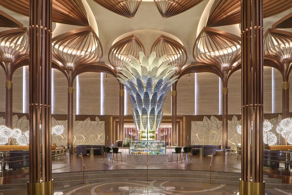 A spacious lobby with a central decorative light fixture, multiple seating areas, and a reception desk. - Inspire Entertainment Resort (Incheon)