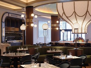 A restaurant interior with booths, round tables, and a bar area. - Inspire Entertainment Resort (Incheon)