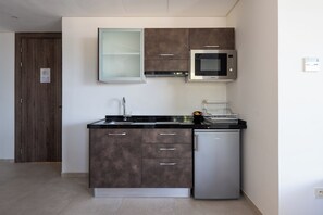 A modern kitchen with a built-in microwave, stainless steel refrigerator, and a double sink. - Le Tanger By Mnar Palm (Al Bahraoyine)