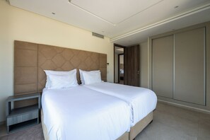 Una habitación de hotel moderna con una cama grande, una mesita de noche y un armario.