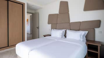 Ein Doppelbett mit Kopfteil, Nachttisch und Kleiderschrank.