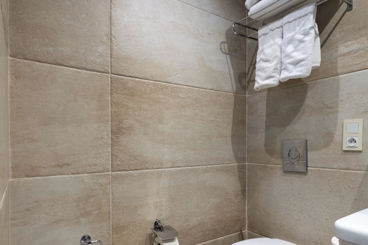A modern bathroom with a bidet, toilet, and sink.