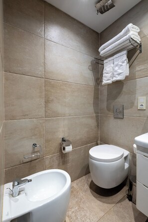 A modern bathroom with a bidet, toilet, and sink. - Le Tanger By Mnar Palm (Al Bahraoyine)