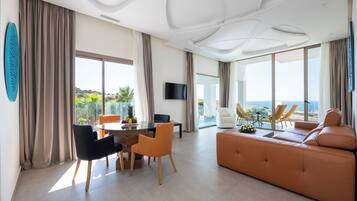 Una sala de estar moderna con sofá, mesa de comedor, sillas y televisor.