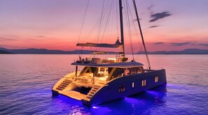A yacht with a spacious deck, multiple levels, and a helipad, set against a sunset backdrop. - Le Tanger By Mnar Palm (Al Bahraoyine)