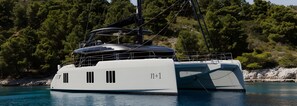 A large yacht docked near a rocky shore with dense forest in the background. - Le Tanger By Mnar Palm (Al Bahraoyine)