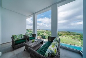 A balcony with wicker furniture and a view of the ocean. - Le Tanger By Mnar Palm (Al Bahraoyine)